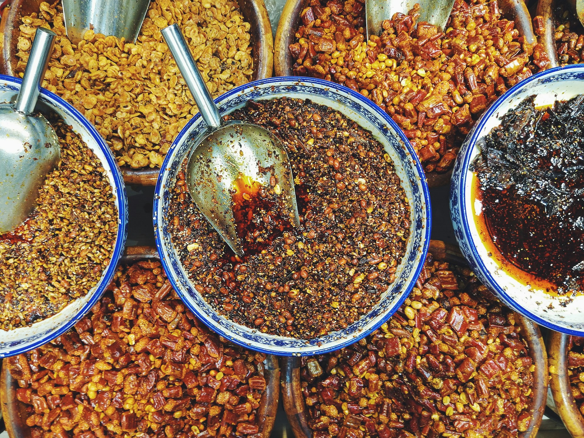 A selection of beautifully arranged spices and sauces in small bowls, ready to be used by guests during the hands-on cooking sessions.