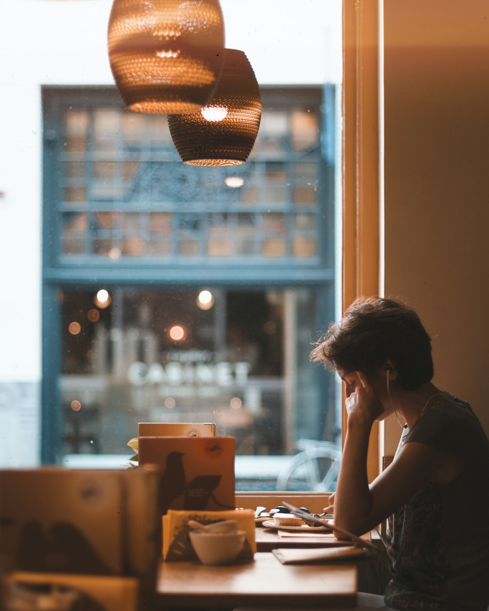 man holding on tablet while sitting on chair in restaurant