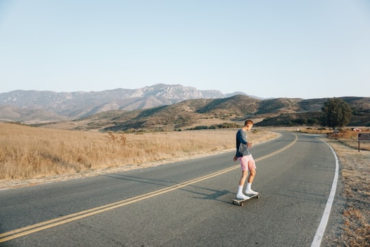 man riding on skateboard on road in Point Mugu State Park United States