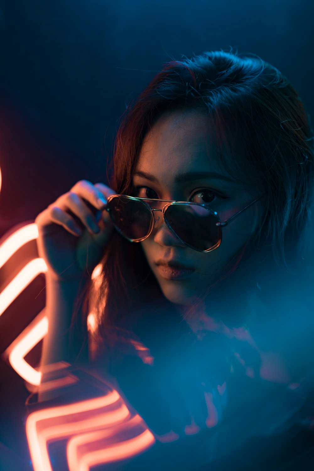 woman holding gold framed sunglasses