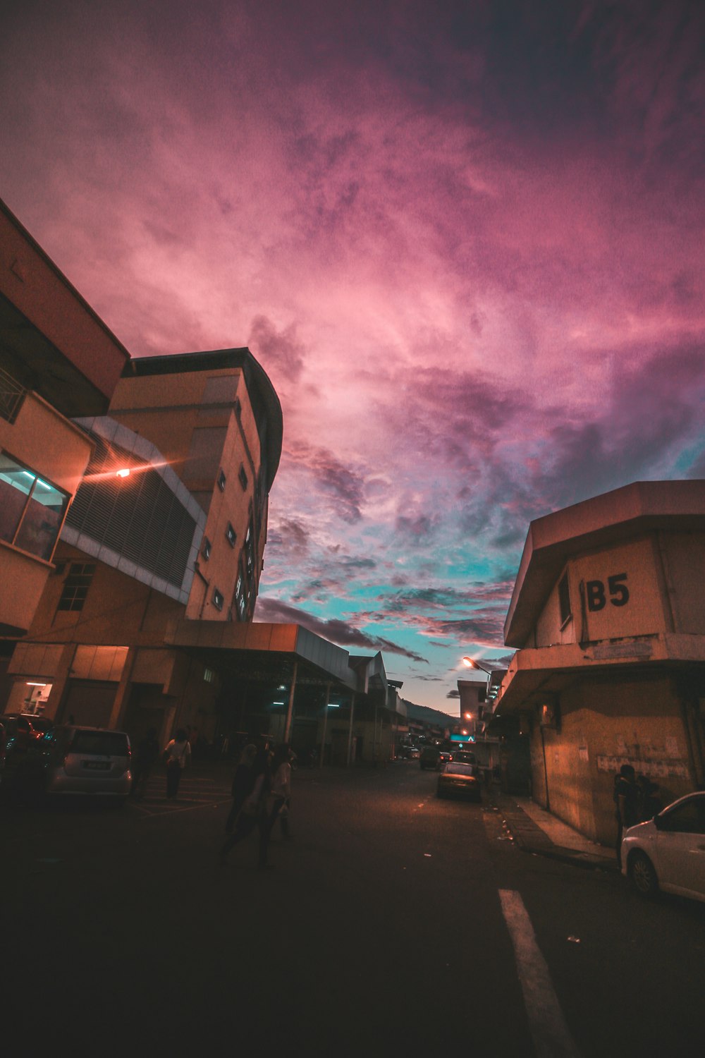 a purple and blue sky over a parking lot