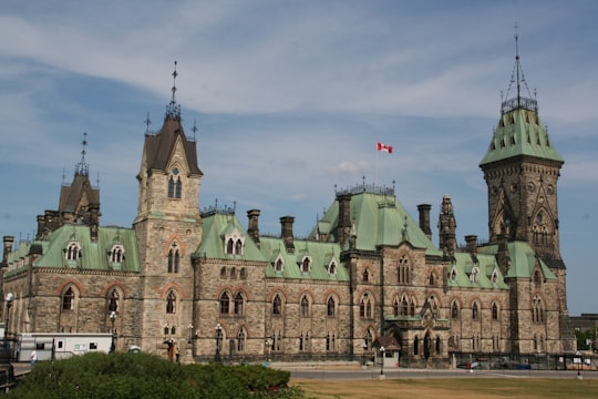 concrete building with green roof during daytime in Parliament Hill Canada