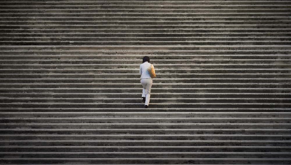 person in white suit walking on staircase