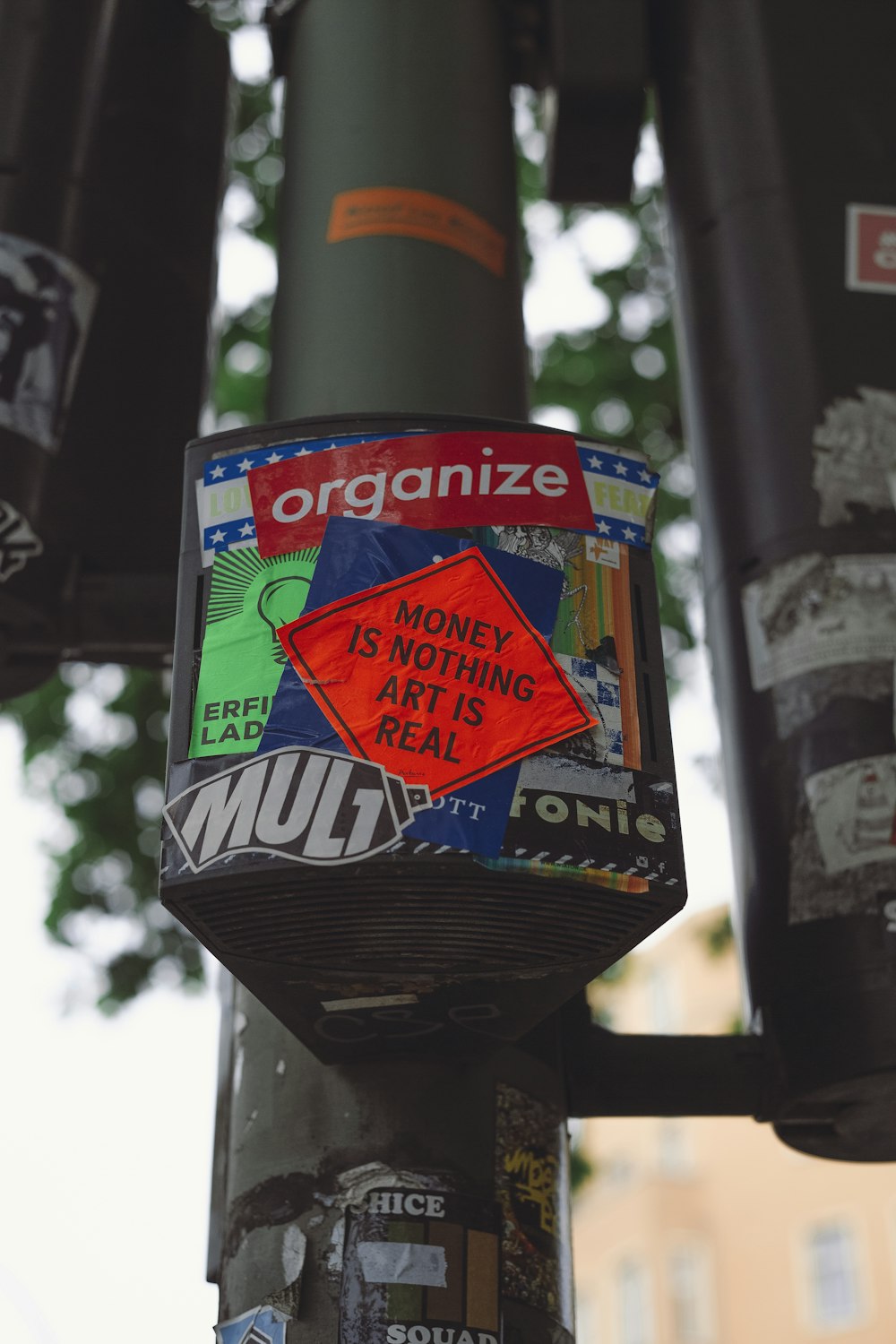 a close up of a street pole with stickers on it