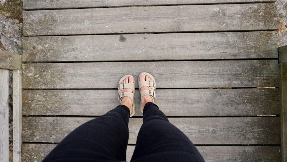 person standing on brown wooden bridge