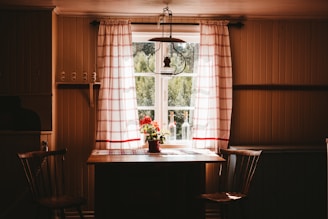 a kitchen table with a vase of flowers on it