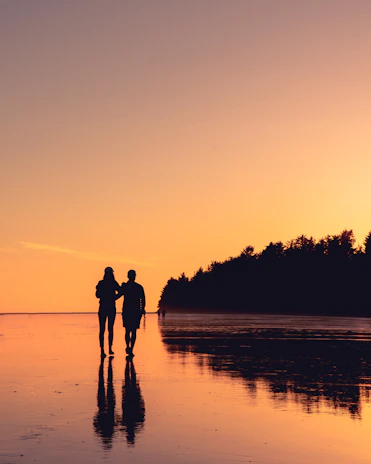 Romantic Latino couple enjoying a sunset walk on a Caribbean beach.