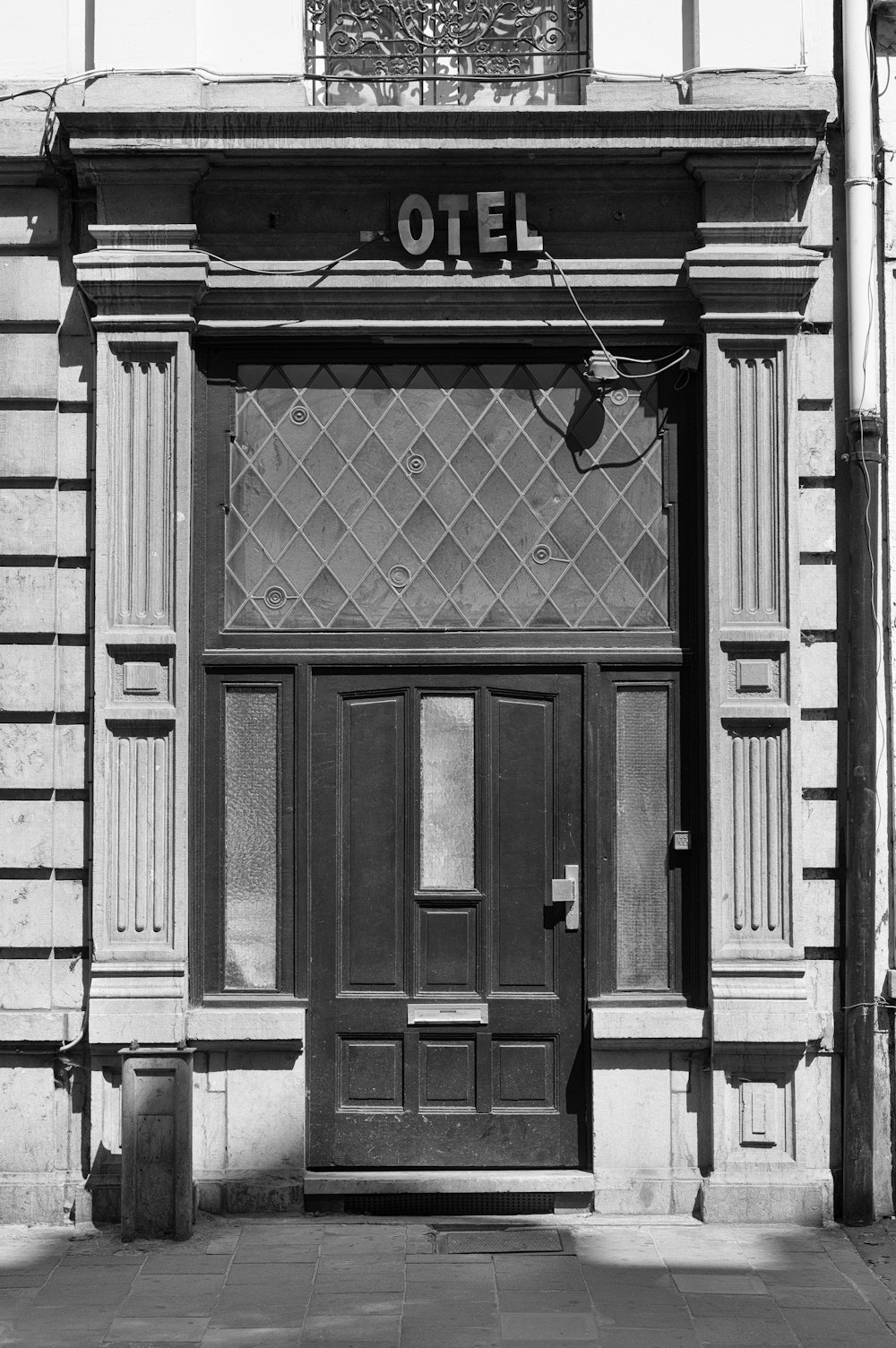 grayscale photo of Hotel building front door