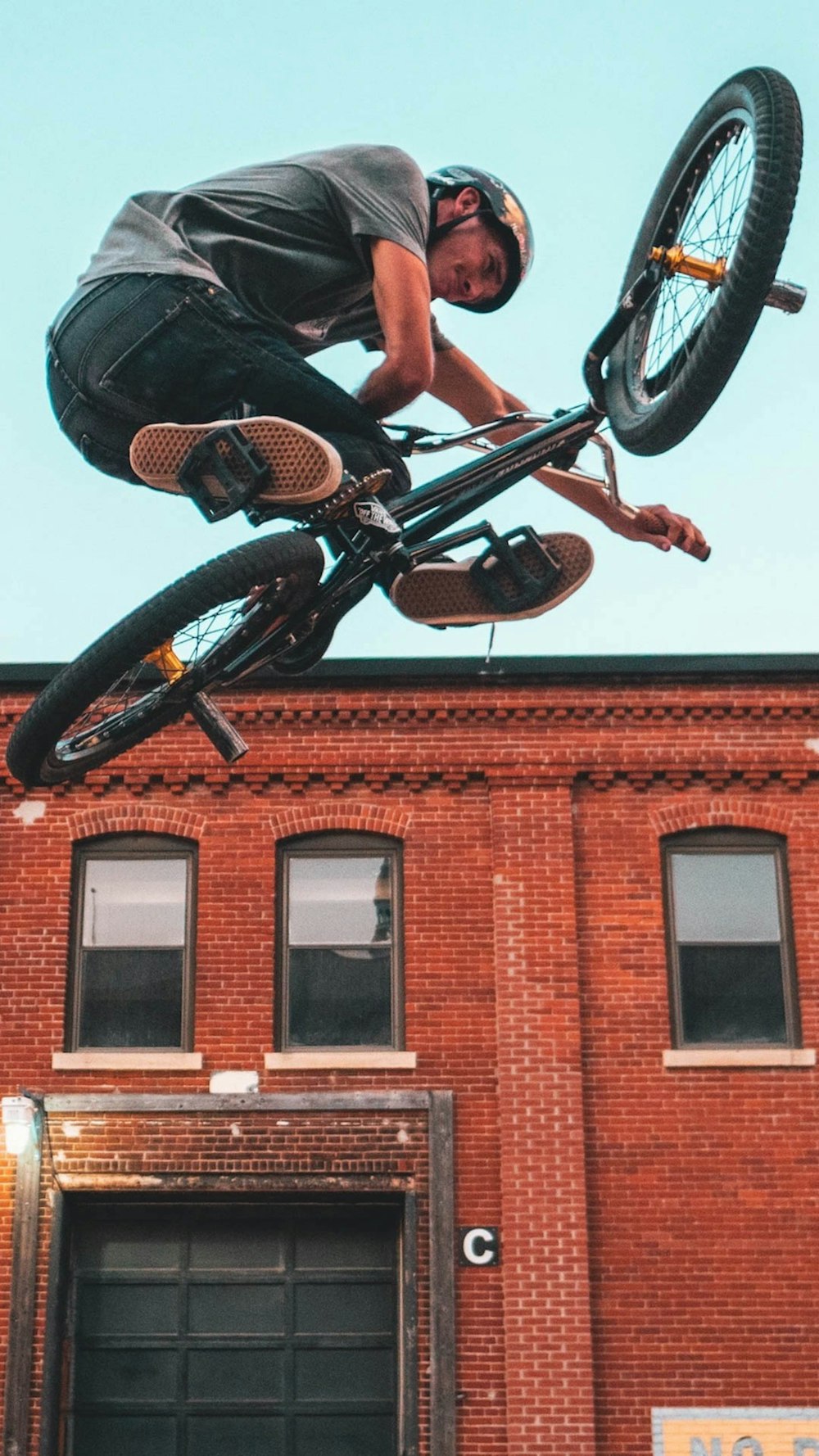 空中で黒いBMXバイクに乗っている男