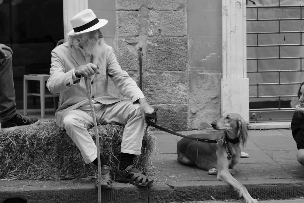 Mann und Hund sitzen im Freien