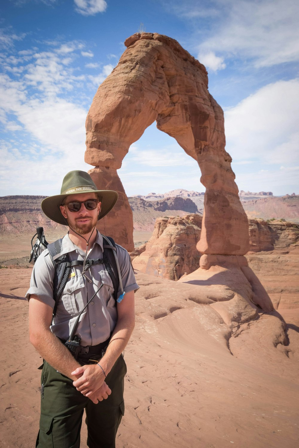 man standing near Delicate Arch