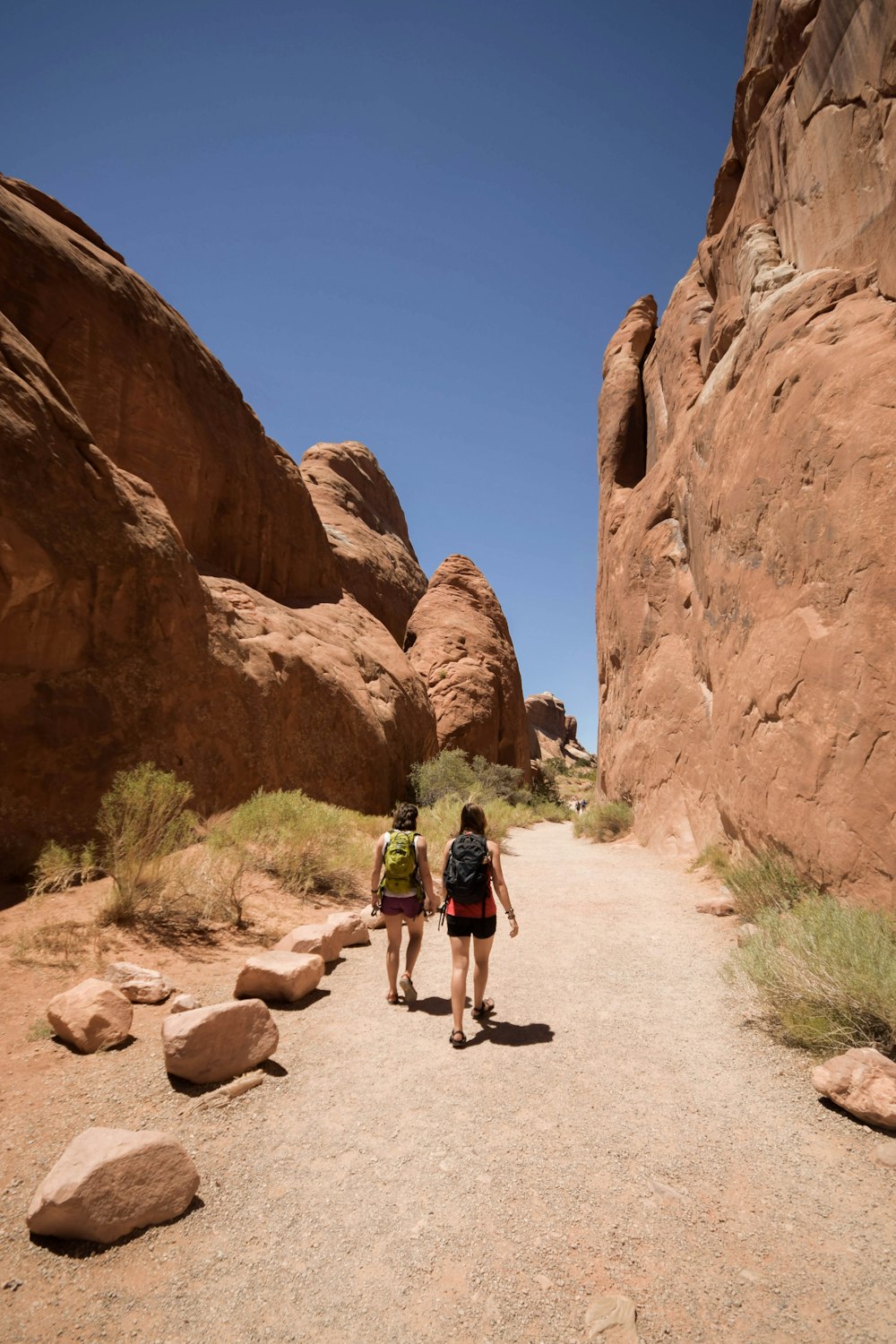 two people walking along rock formations