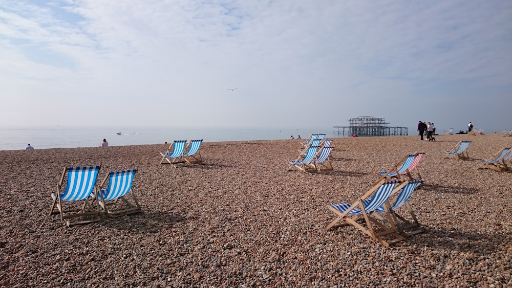 blue and white wooden chairs near seaside