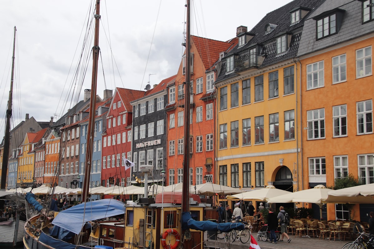 Copenhagen October — Nyhavn canal with colourful buildings reflected in still water in autumn light