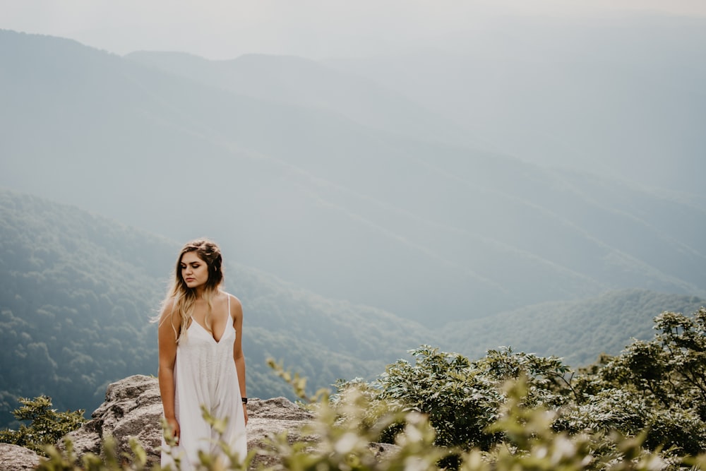 woman standing on brown rocky terrain at high altitude