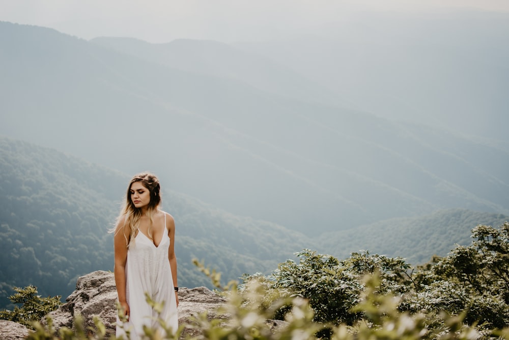 Femme debout sur un terrain rocheux brun à haute altitude