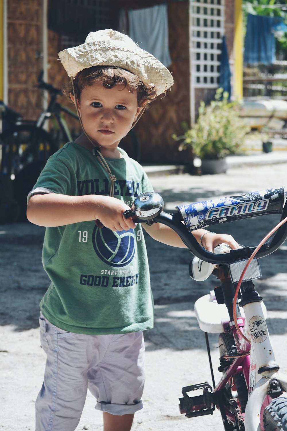 chico sosteniendo una bicicleta blanca y negra