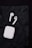 A pair of wireless earbuds with a white charging case are placed on a crumpled black background.
