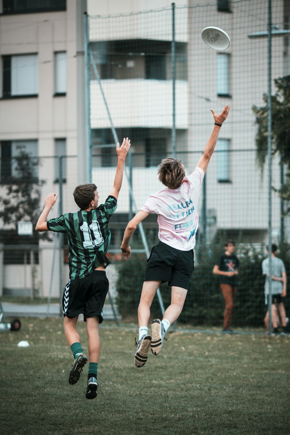 Dos hombres alcanzando el frisbee mientras saltan