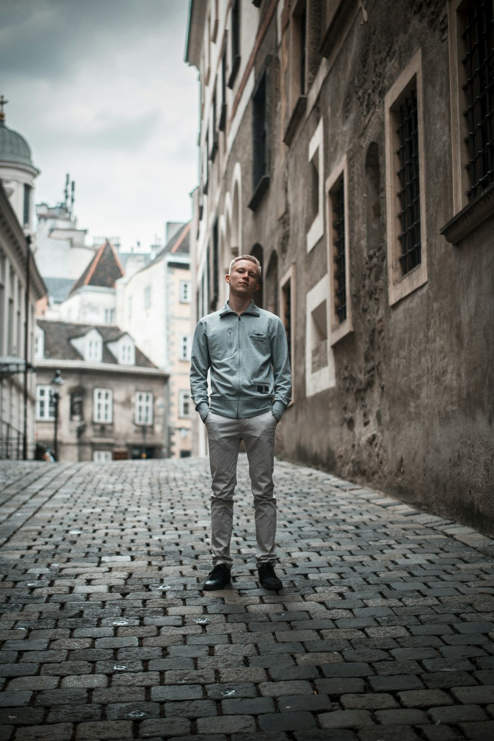 man sitting on street near building during daytime