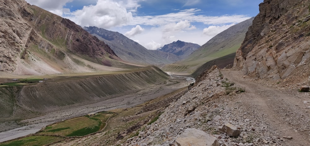 landscape photography of mountains under cloudy blue sky