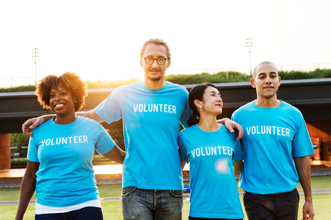 two men and women wearing blue volunteer-printed crew-neck t-shirts