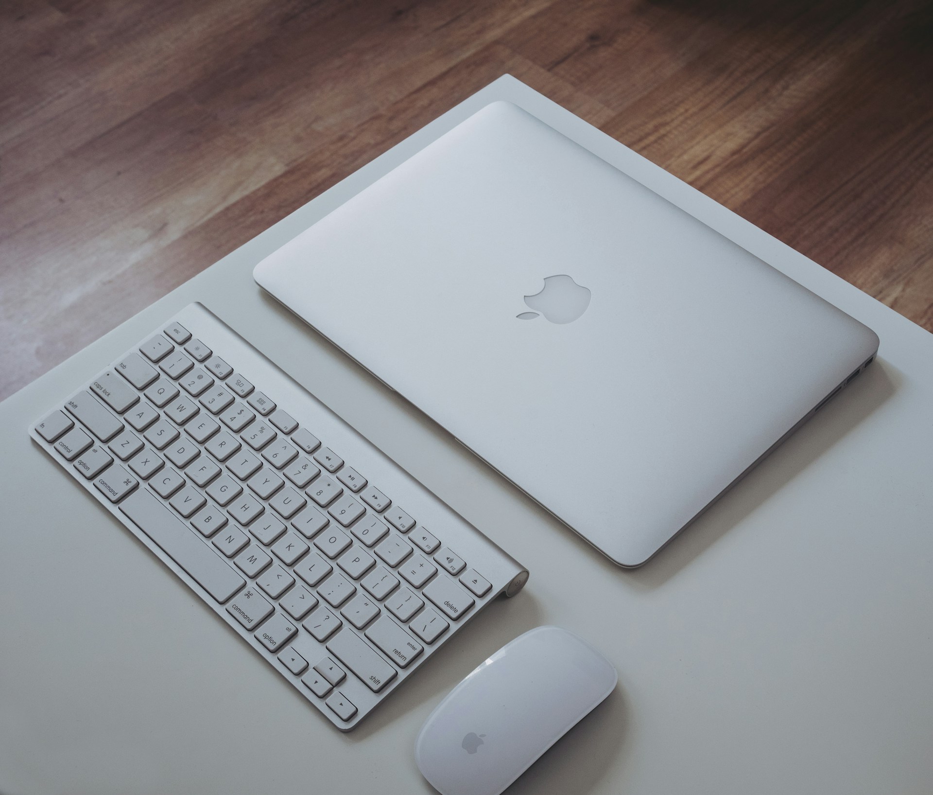 silver MacBook near Apple Magic Keyboard and Apple Magic Mouse on white surface
