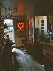 A cozy, softly lit corner café with vintage decor and a single glowing candle on the table.