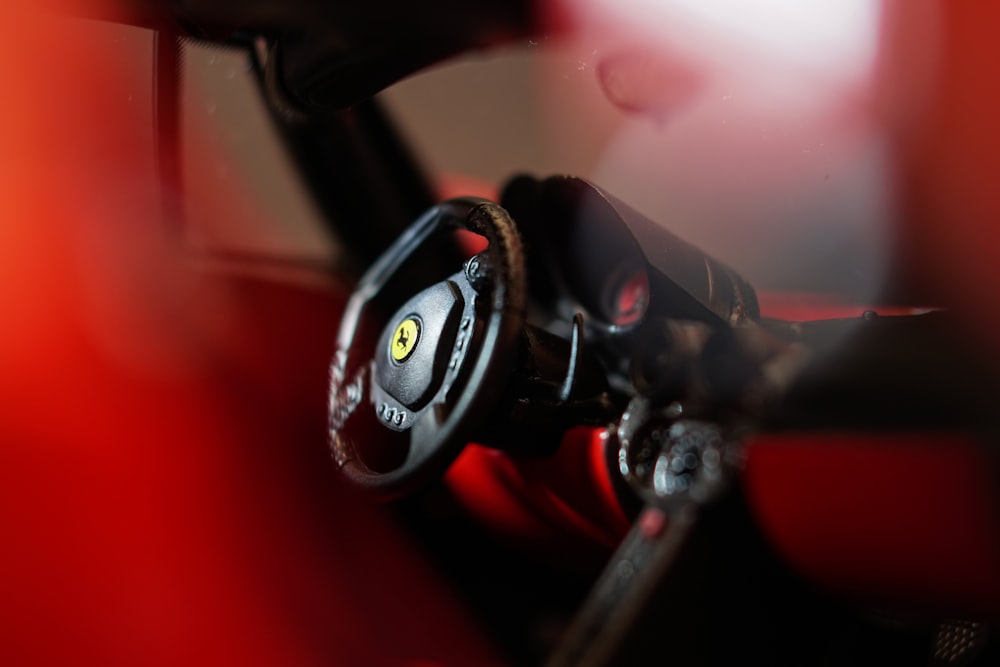 fotografia con messa a fuoco selettiva del volante Ferrari nero e rosso