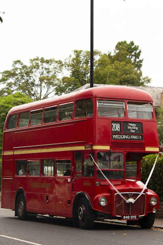 Guests happily boarding a charming shuttle bus with wedding decorations.