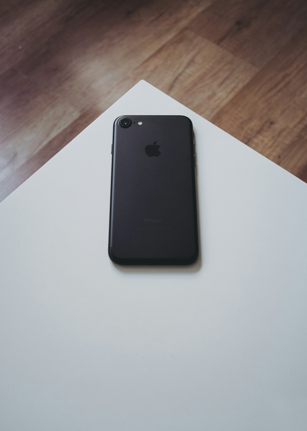 iPhone 7 preto na mesa de madeira branca