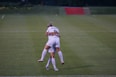 woman hugging her co player on green field