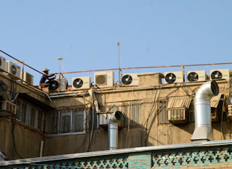 Technician repairing an air conditioning unit outside a cozy Magnolia home on a sunny day.