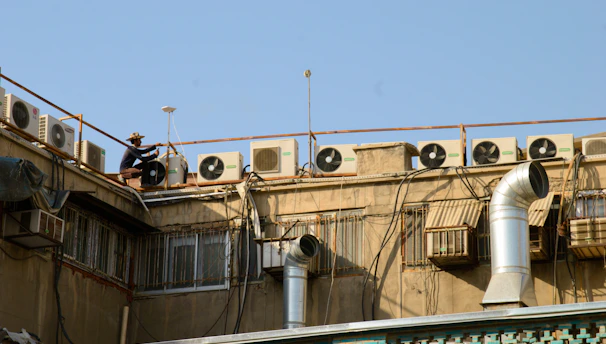 Technician repairing an air conditioning unit outside a cozy Magnolia home on a sunny day.
