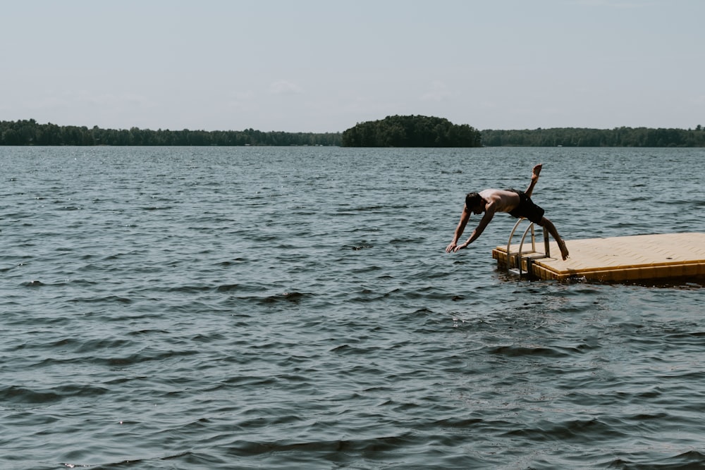 man diving on large body of water