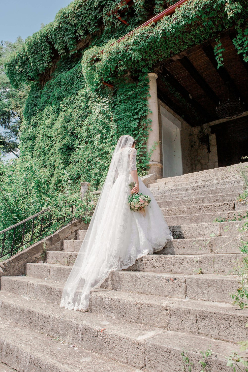 sposa che cammina sulla scalinata vicino al giardino