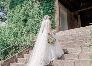 bride walking on stairway near garden