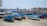 A sunlit Maltese harbor with colorful fishing boats gently bobbing in the water.