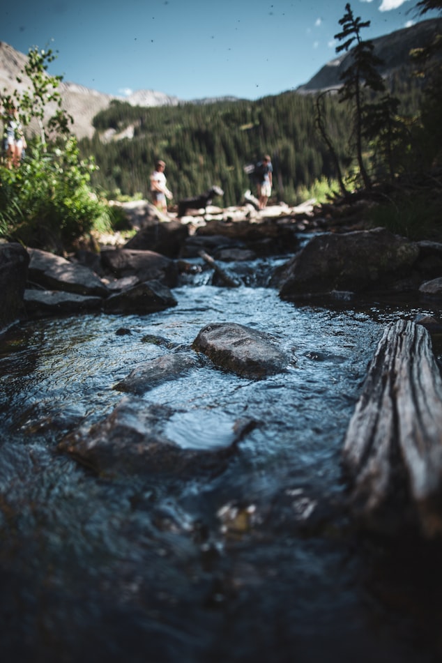 stream in colorado with people hiking behind it