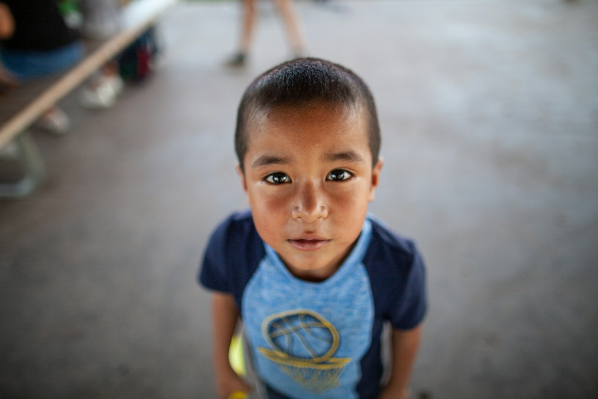 a young boy standing in front of a group of people