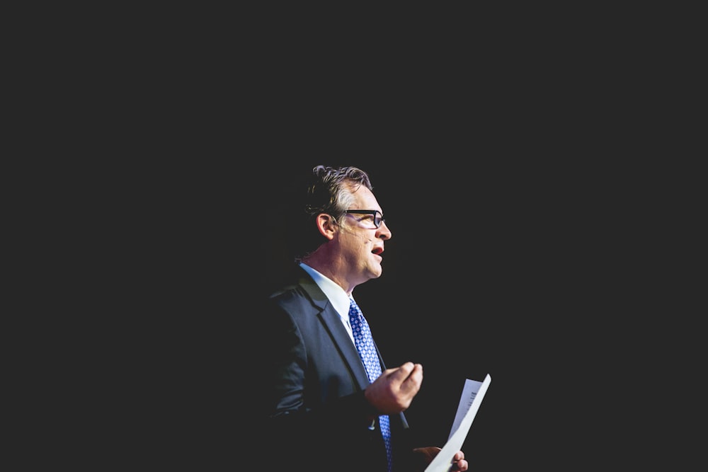 a man in a suit and tie holding a piece of paper