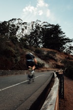 A cyclist in motion on a winding road, with subtle blue-toned motion blur in the background.