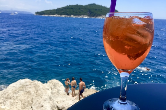 A vibrant beach scene with colorful mocktails and friends enjoying the sun.