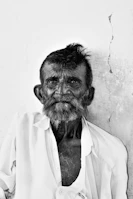 A candid street portrait of a smiling elderly man with weathered features.