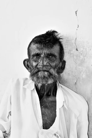 A candid street portrait of a smiling elderly man with weathered features.