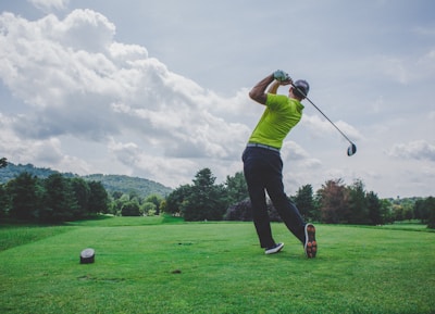 photo of man swinging golf driver