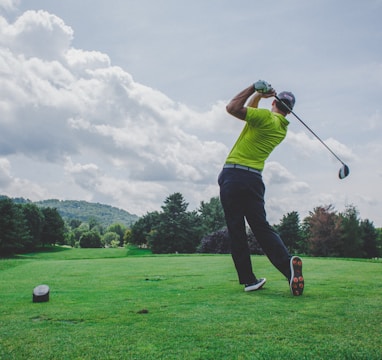 photo of man swinging golf driver