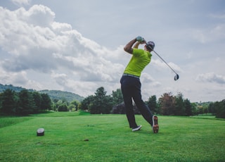 photo of man swinging golf driver