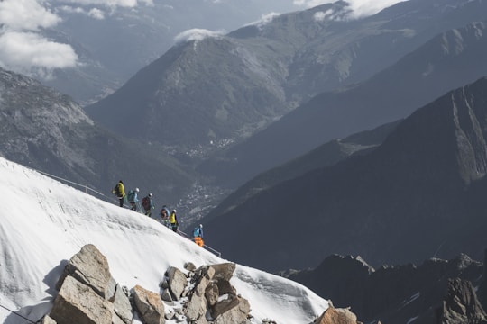 Climbers ascending rocky slopes with the snowy peak of Aconcagua in the background.