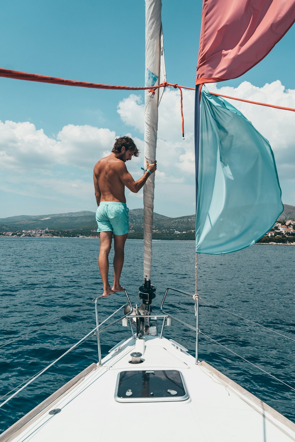 man standing on rail of boat